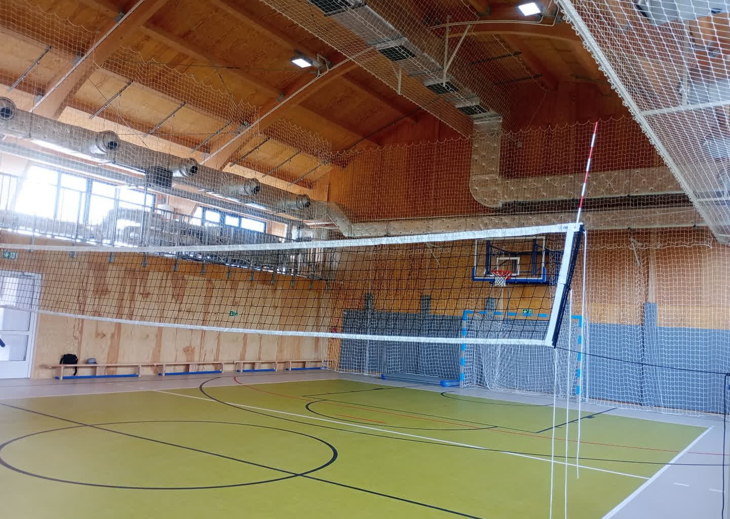 Wnętrze hali sportowej z boiskiem do siatkówki i koszykówki